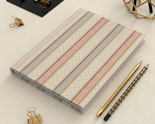 Light gray and pink notebook with text on a dark surface with office supplies