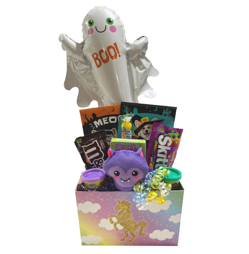 A Halloween-themed gift basket featuring a white foil ghost balloon with 'BOO!' printed on it, a purple plush toy, candy bags, and a glittery unicorn box on a white background.