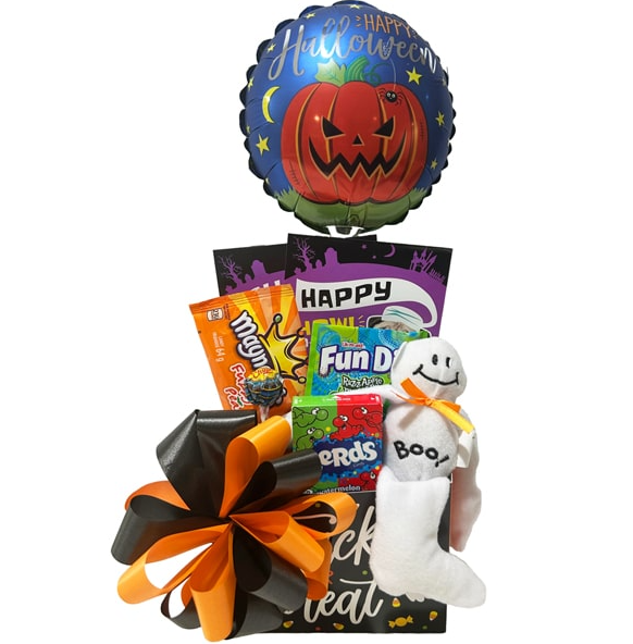 A Halloween-themed gift basket filled with assorted candy, a plush ghost, and a large black and orange bow, topped with a round foil balloon featuring a jack-o'-lantern and the words 'Happy Halloween'.
