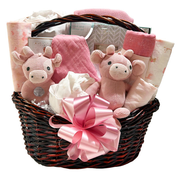 A baby gift basket set in a dark brown wicker basket with a large pink ribbon bow, filled with pink plush toy animals, pink blankets, baby wipes, and patterned baby clothes on a white background.